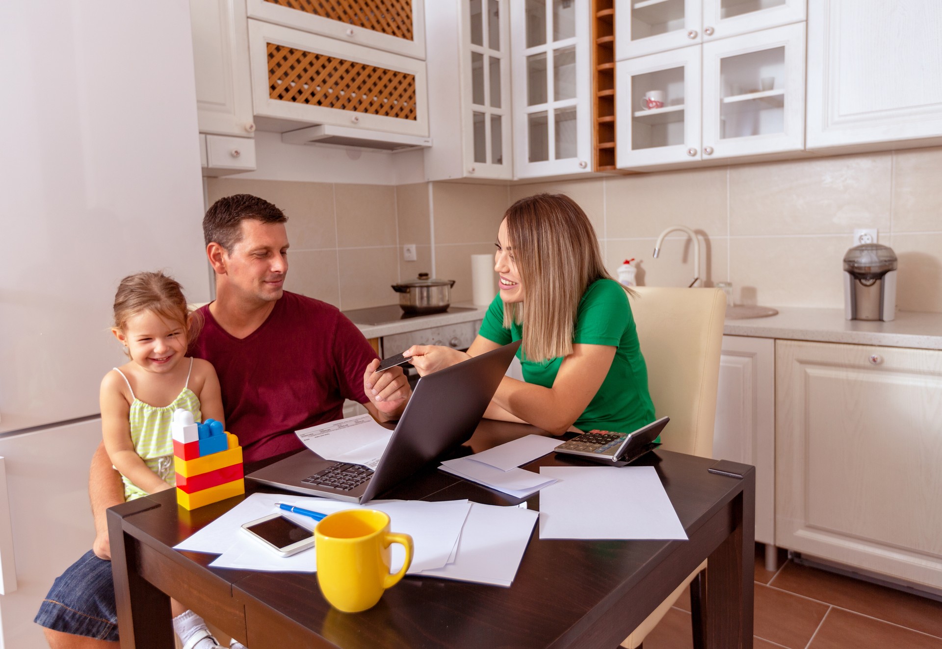 Busy Family Home with Father Working as Mother Prepares Meal